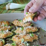 A hand holding a Crab Rangoon Jalapeno Popper with cream cheese and crab.