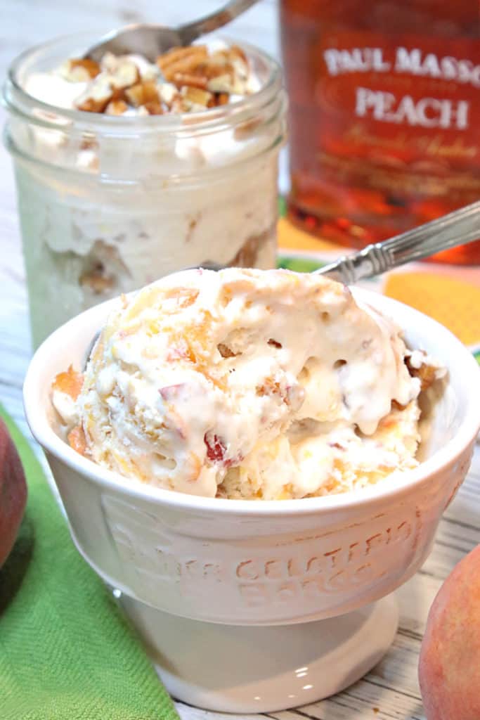 A white dish filled with No-Churn Peach Pecan Ice Cream and a spoon.