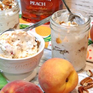 A bowl and a couple of mason jars filled with no-churn peach and pecan ice cream with peaches on the side and pecans on the table