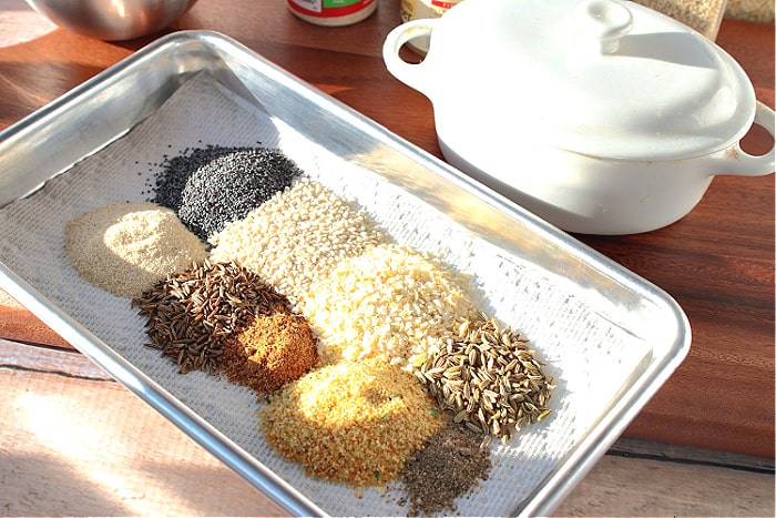 A small silver baking dish covered with piles of best homemade everything seasoning blend ingredients.