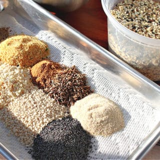 Everything seasoning blend on a small baking sheet with a container filled with it in the background.