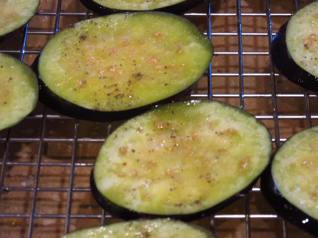 Eggplant slices topped with oil and pepper.
