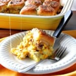 A Scrambled Egg Breakfast Slider on a white plate with a fork.