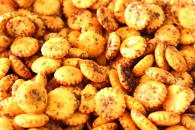 A pile of oyster crackers with sriracha sauce baked on.