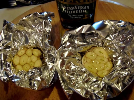 Garlic bulbs wrapped in foil ready for roasting.