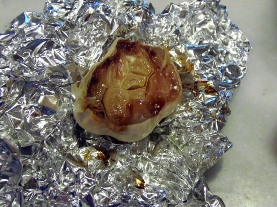 A golden brown roasted garlic bulb after roasting in foil.