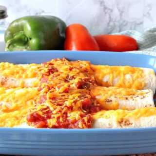Three air fryer breakfast burritos in a blue casserole dish with salsa and melted cheese