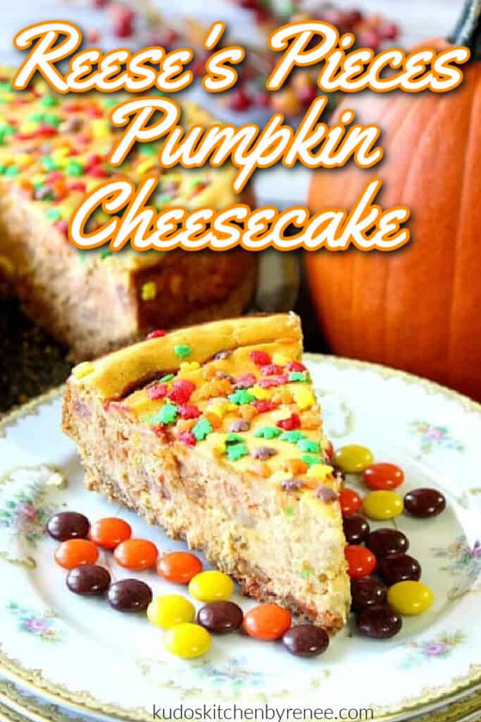 A closeup vertical image of a Reese's Pieces Pumpkin Cheesecake with fall sprinkles and a title text overlay graphic.