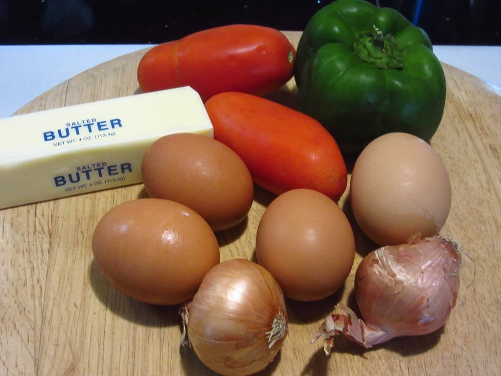 Eggs, green pepper, tomato, shallots, and butter for making Air Fryer Breakfast Burritos