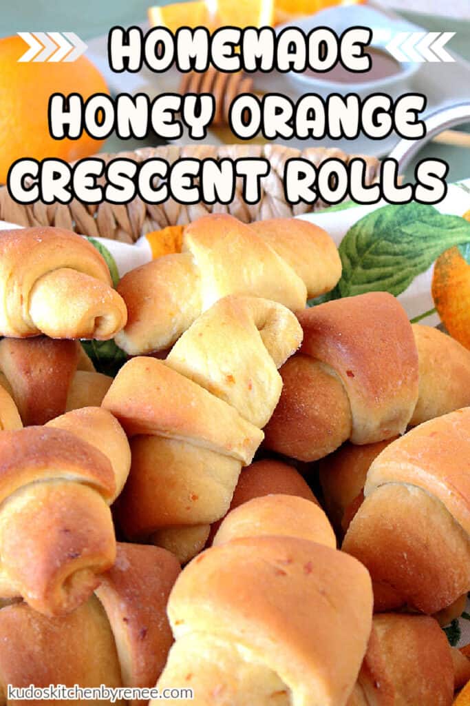 Closeup vertical image of honey orange crescent rolls with orange zest flecks in the dough along with a title text overlay graphic.