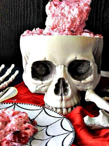 A skull filled with Brain Food Jello Salad and a red napkin.