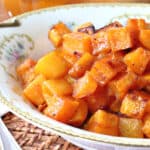 An offset horizontal photo of a pretty china bowl filled with honey roasted butternut squash