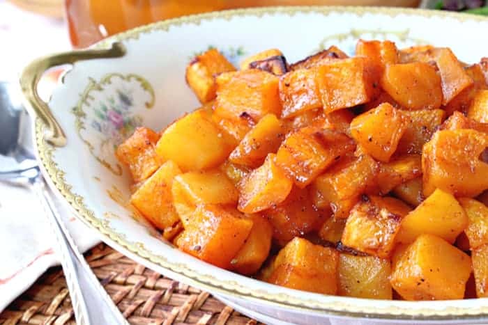 An offset horizontal photo of a pretty china bowl filled with honey roasted butternut squash