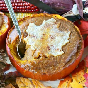 A Pilgrim Pumpkin Pie baked in a real pumpkin with a pie crust leaf on top.