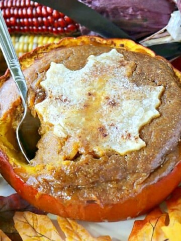 A Pilgrim Pumpkin Pie baked in a real pumpkin with a pie crust leaf on top.