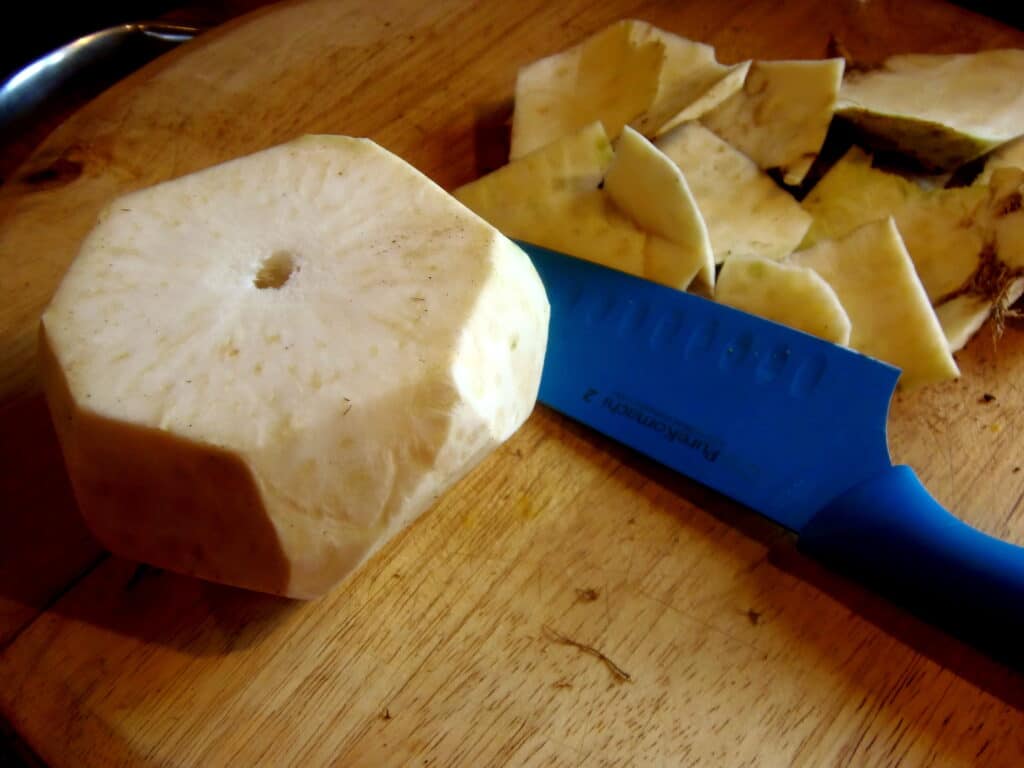 A peeled celery root on a cutting board.