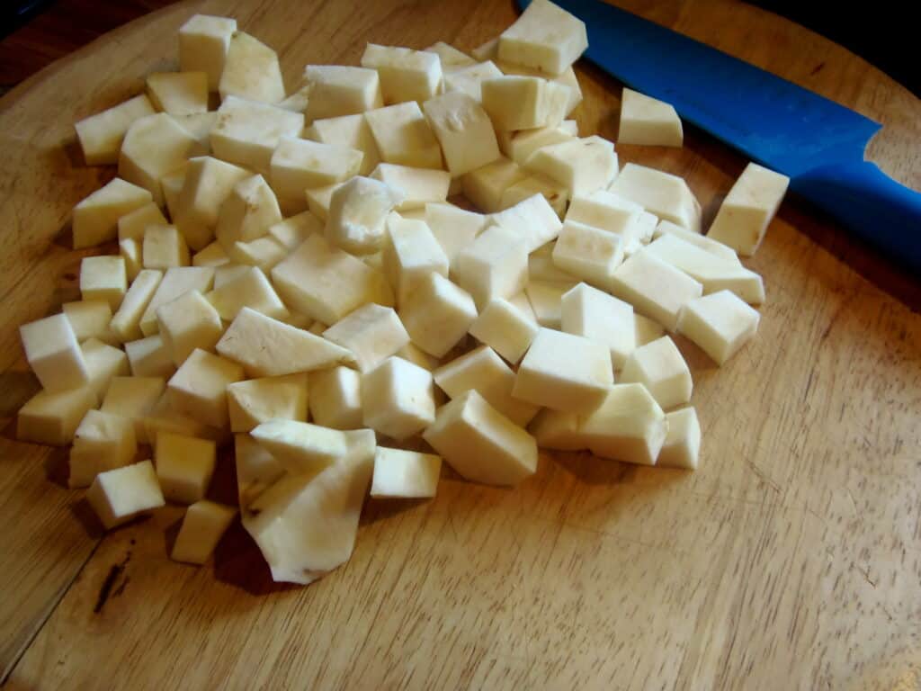 A chopped celery root on a cutting board.