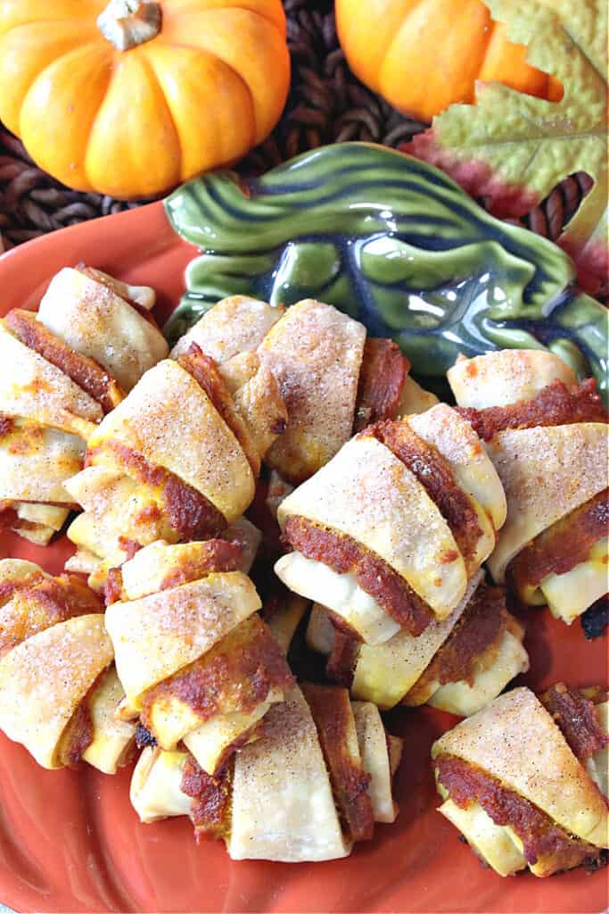 A closeup up overhead vertical photo of Pumpkin Pie Bites with cinnamon sugar topping on an orange pumpkin plate