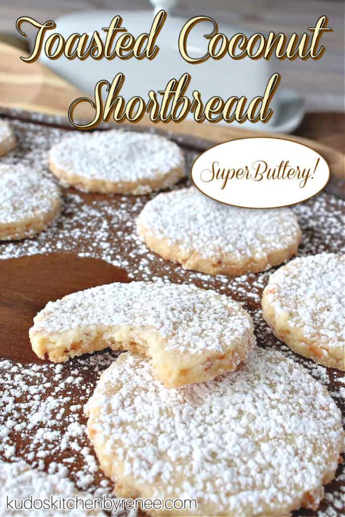 A vertical closeup title text image of Toasted Coconut Shortbread Cookies on a wooden tray with a bite taken out of one cookie.