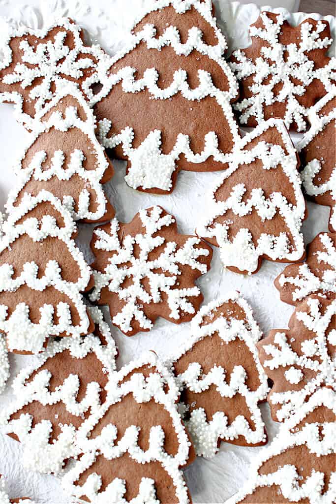 Super closeup vertical image of Gingerbread Trees and Snowflakes on a white background with royal icing and nonpareils.