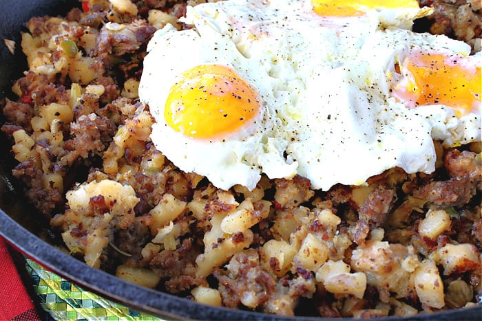 Closeup horizontal image of fried eggs on top of Grinch Who Hash.