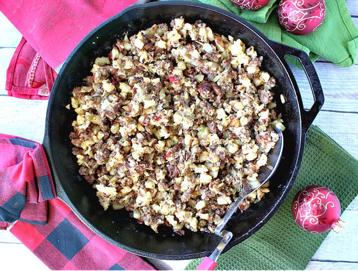 An overhead photo of a cast iron skillet filled with Grinch Who Hash along with red and green napkins and Christmas ornaments