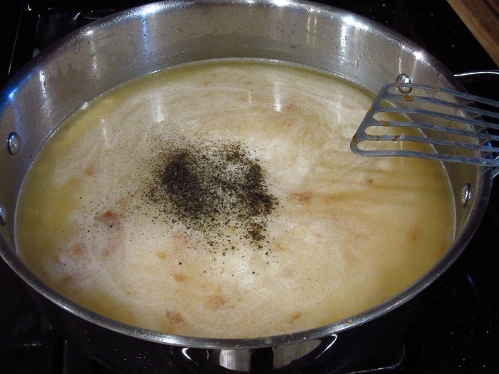 Seasonings added to a skillet with chicken stock.