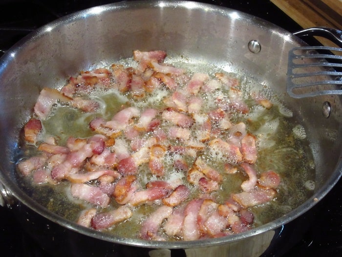 Bacon frying in a skillet.