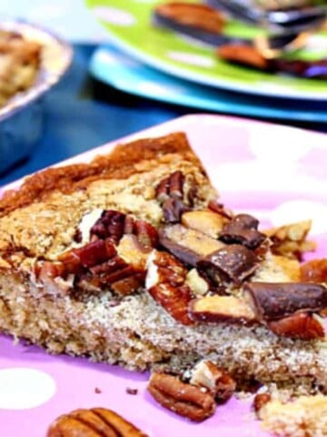 A slice of Retro Heath Bar Cake on a pink polka dot plate.