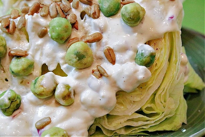 Super closeup horizontal photo of homemade blue cheese dressing on a Wedge Salad with Wasabi Peas
