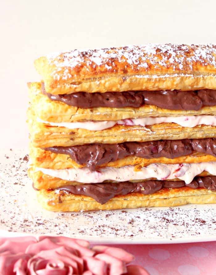 A closeup vertical image of a Chocolate Cherry Pastry Tower with layers of puff pastry and chocolate and cherry cream cheese filling.