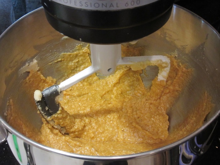 A wet cookie dough batter in a stand mixer.