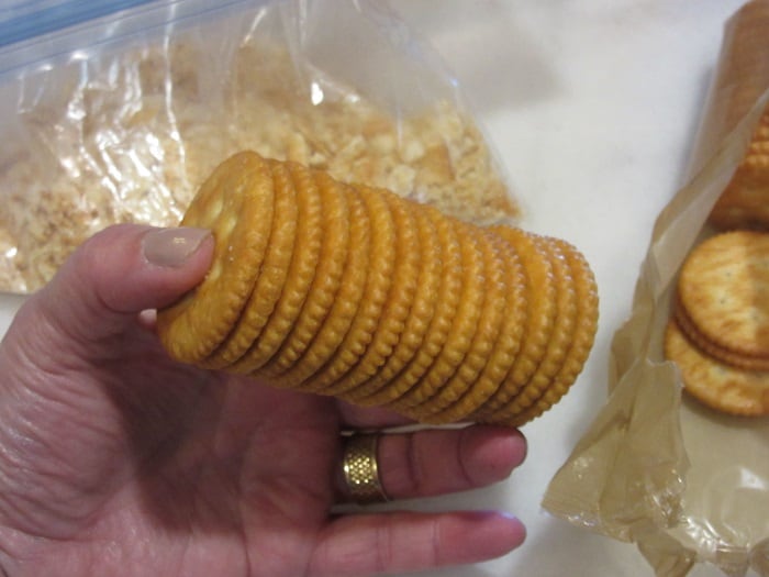 A sleeve of ritz crackers being held by a hand.