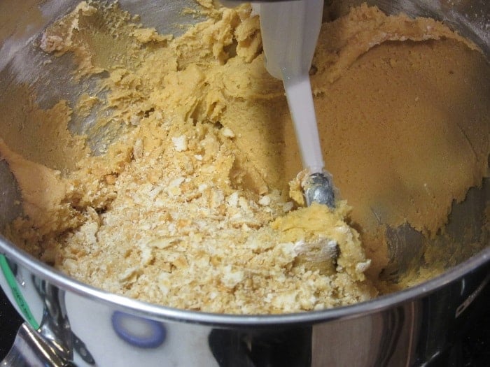 Crushed ritz cracker crumbs added to a cookie dough in a stand mixer.