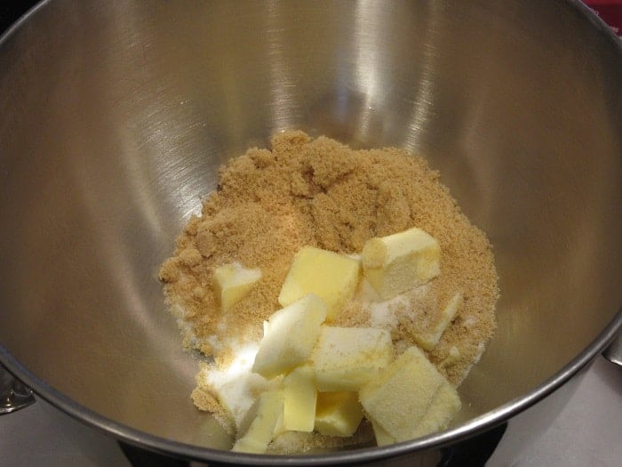 A mixing bowl with butter and sugars inside.