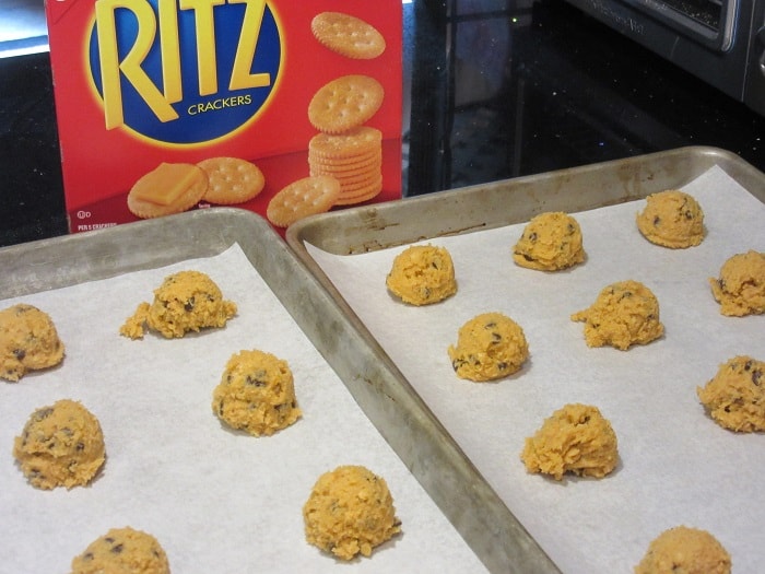 Unbaked ritz cookies on baking sheets with parchment paper.