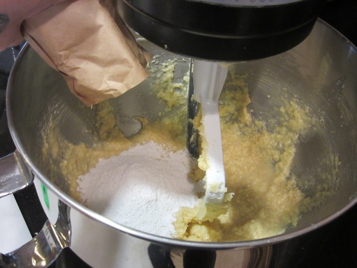 Dry pudding mix being added to a cookie dough.