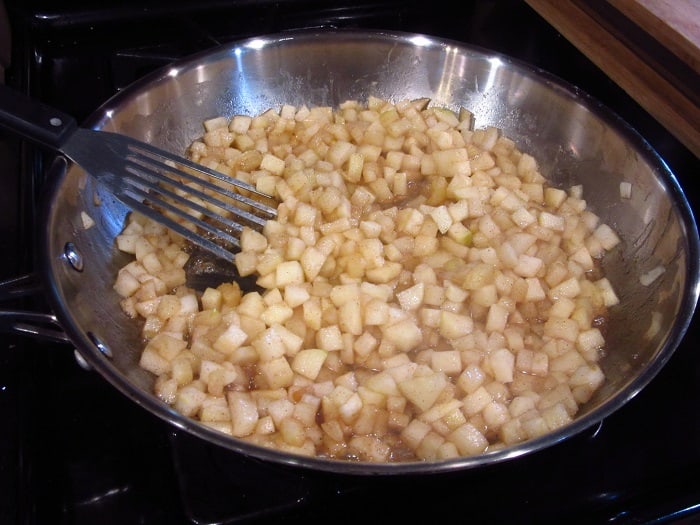 Cooking diced apples in a skillet.