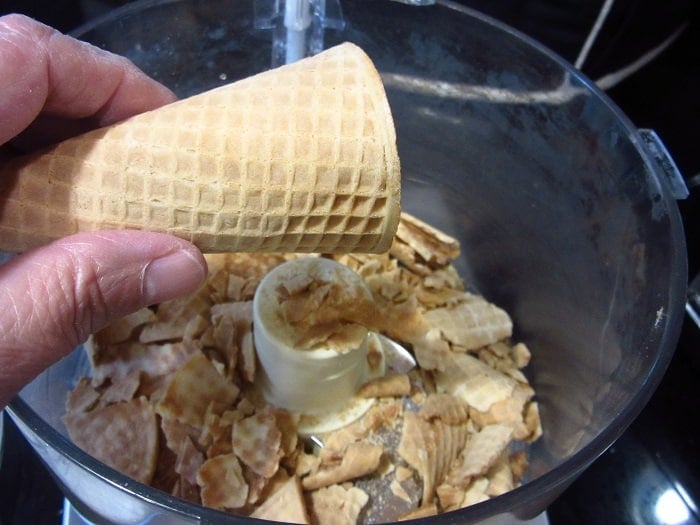 A sugar cone being added to a food processor.