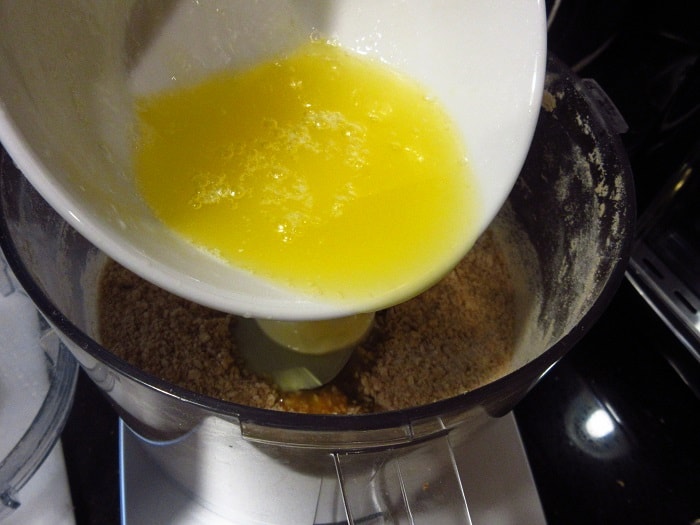 Melted butter being added to a food processor.