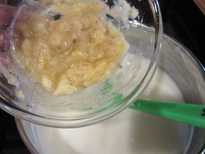 Mashed bananas going into a saucepan to make a banana cream pie custard.