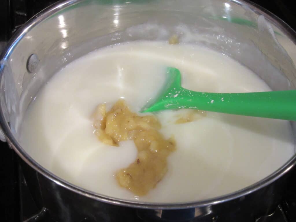 Mashed bananas and milk in a saucepan on the stove.