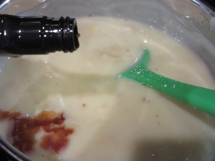 Vanilla extract being added to a thickened custard for making banana cream pie.