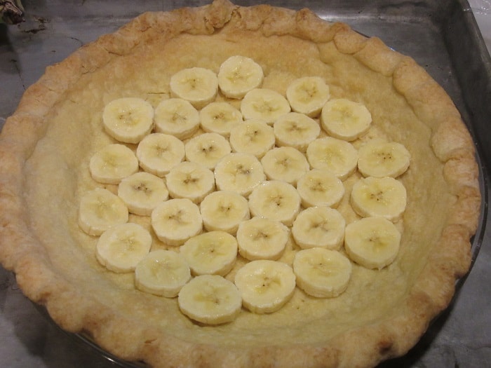 Sliced bananas on a prebaked crust.
