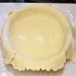 A pie plate filled with a rolled piece of Mom's Homemade Pie Crust.