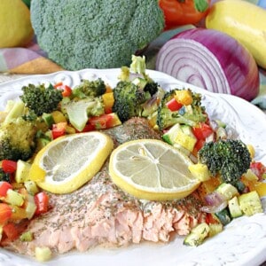 Roasted Rainbow Trout on a plate with lemon slices.