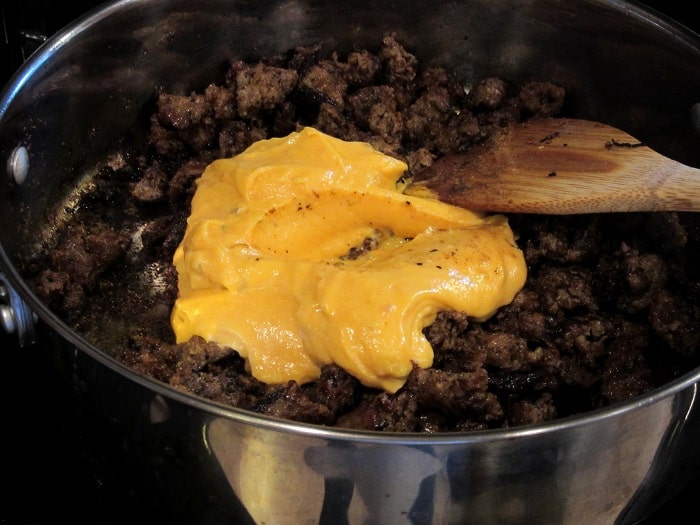 Cheese added to a skillet with ground sausage