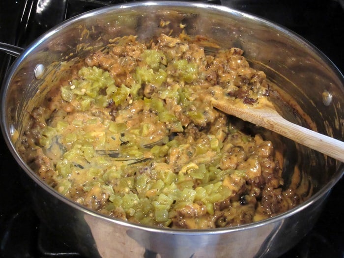 Chilis and cheese in a skillet with ground sausage.