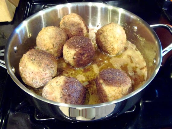 Browning Scotch Eggs in a large skillet.