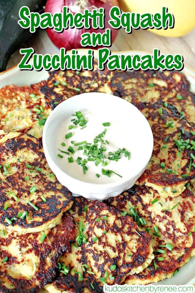 A vertical closeup image of Spaghetti Squash Pancakes on a platter with chives and sour cream garnish.